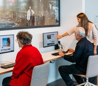 woman assisting people on computers
